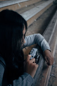 Side view of young woman using camera