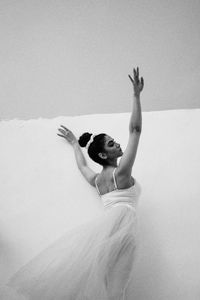 Rear view of woman sitting on bed at home