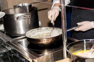 Midsection of person preparing food in kitchen