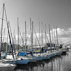 Sailboats moored in lake against sky