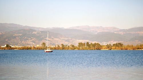 Sailboat in lake against sky