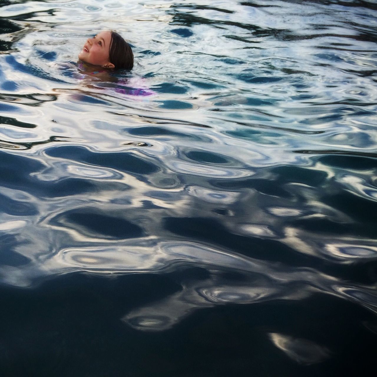 water, lifestyles, leisure activity, high angle view, waterfront, swimming, rippled, swimming pool, reflection, childhood, lake, enjoyment, vacations, sea, person, fun, wet, day
