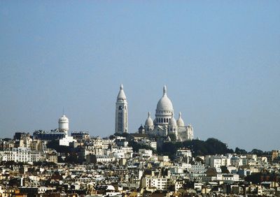 Buildings in city against clear sky