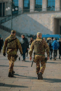 Rear view of soldiers walking on street