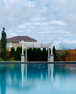 Swimming pool by building against sky