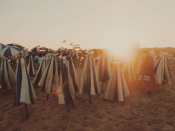 Clothes hanging on sand at beach against clear sky