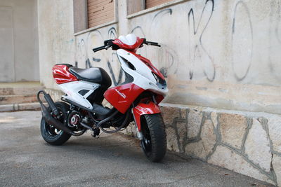 Motor scooter parked on street against building