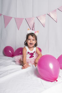 Portrait of a smiling girl with pink balloons