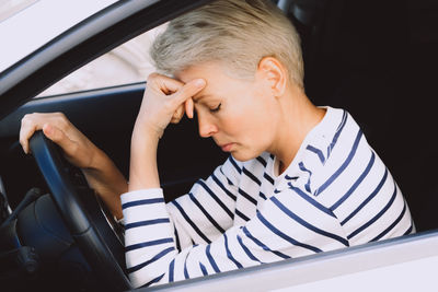 Close-up of young woman sitting in car