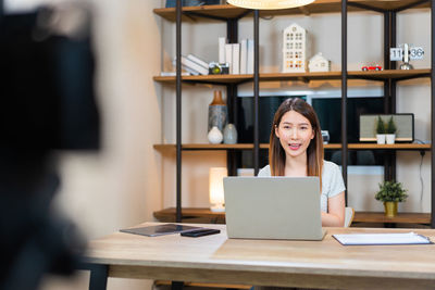 Young woman using laptop at table