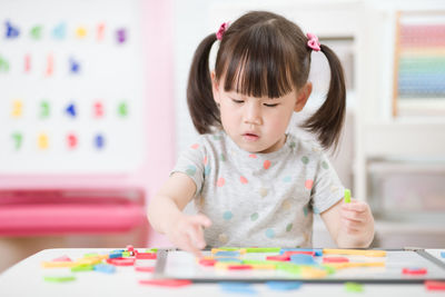 Young girl playing creative toy blocks for homeschooling