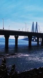 Bridge over calm sea against sky