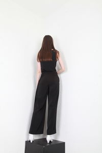 Rear view of woman standing against white background