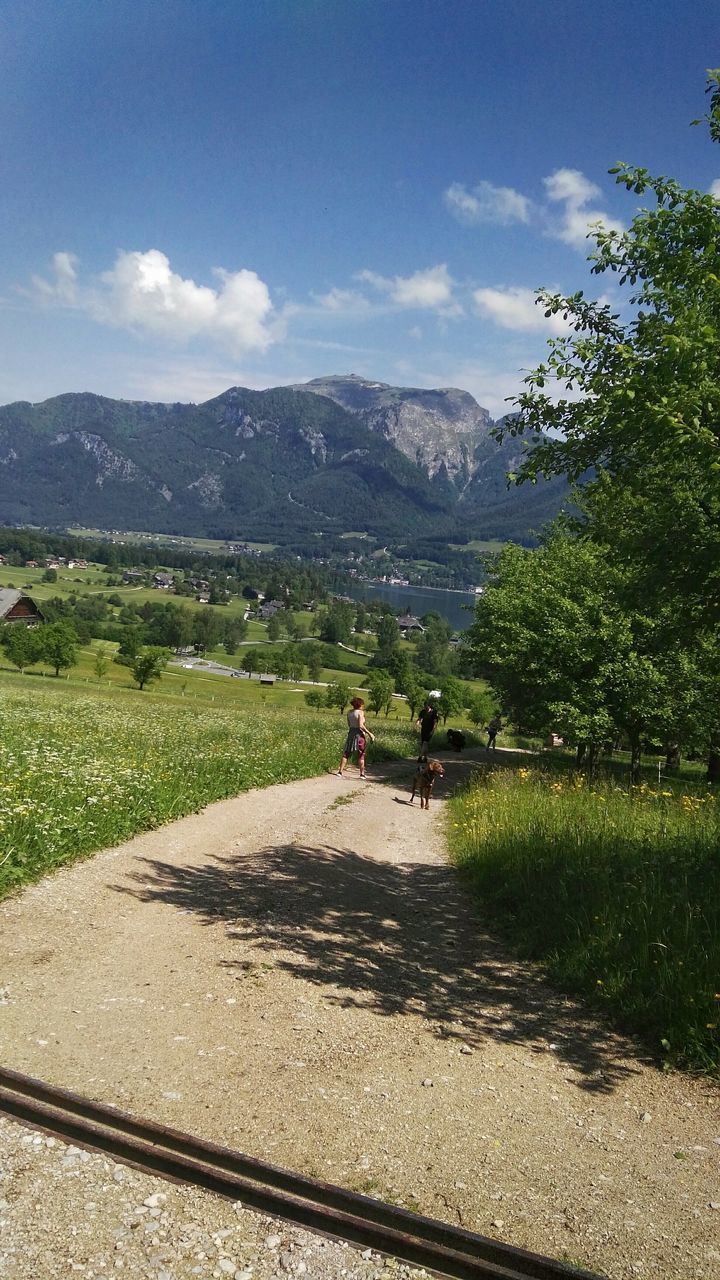 plant, mountain, sky, landscape, nature, real people, beauty in nature, cloud - sky, environment, scenics - nature, day, tree, lifestyles, mountain range, adult, women, tranquil scene, people, tranquility, grass, outdoors