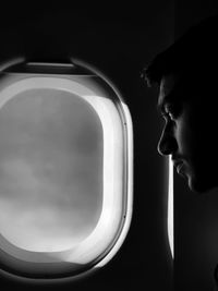Close-up portrait of young man looking through airplane
