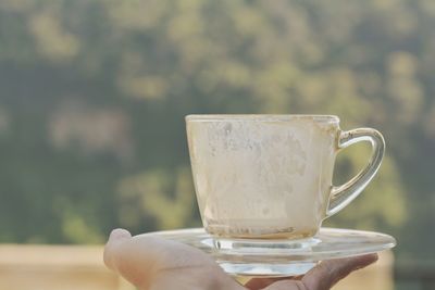 Close-up of hand holding coffee cup