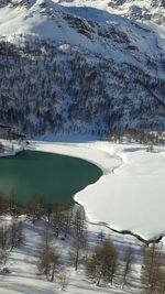 Scenic view of frozen lake by snowcapped mountain