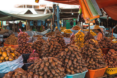 Potatoes in baskets for sale at market stall