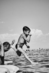 Friends enjoying in sea against sky