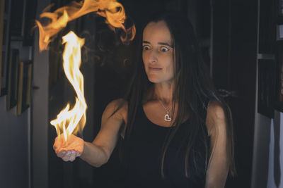 Beautiful woman surprised while holding a flame of fire in her hand