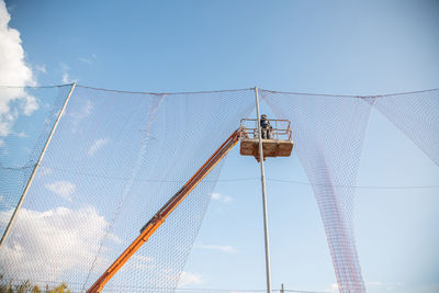 Low angle view of crane against sky