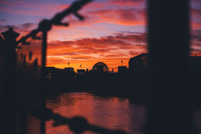 Silhouette buildings against sky during sunset