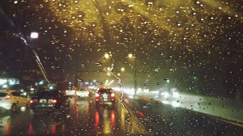 Close-up of wet illuminated city during rainy season