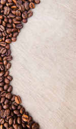 High angle view of roasted coffee beans on wooden table