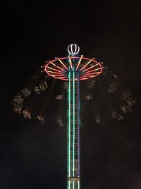 Low angle view of illuminated ferris wheel against sky at night