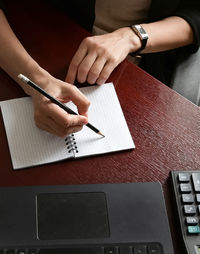 Midsection of man working on blueprint