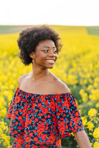 Close-up of a smiling young woman standing on field