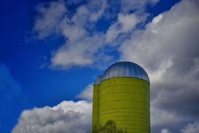 Low angle view of bird flying against blue sky