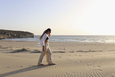 Young woman walking on sand at beach, patara, turkiye