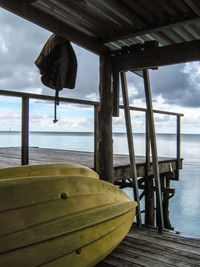 Pier on sea against cloudy sky