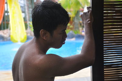 Side view of shirtless boy standing in swimming pool