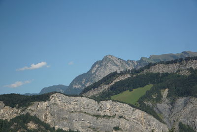 Low angle view of mountain against blue sky