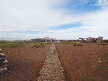 Houses on road by building against sky