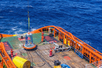 Able bodied seamen and rigger attending a personal basket transfer from a barge to a boat deck