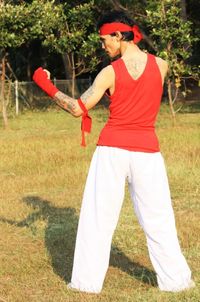 Man holding umbrella while standing on field