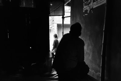 Rear view of silhouette man standing in building