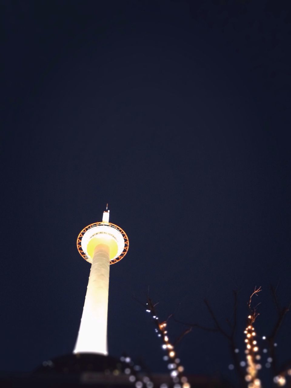 illuminated, low angle view, night, clear sky, copy space, lighting equipment, built structure, architecture, building exterior, tall - high, communications tower, tower, sphere, communication, travel destinations, city, street light, international landmark, sky, tourism