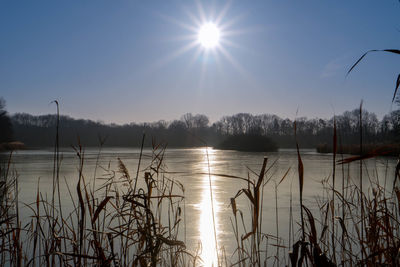 Scenic view of lake against sky on sunny day