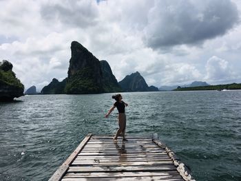 Woman walking on pier over sea against sky in natural park of phang-nga bay in thailand 
