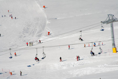 High angle view of people skiing on snow covered mountain