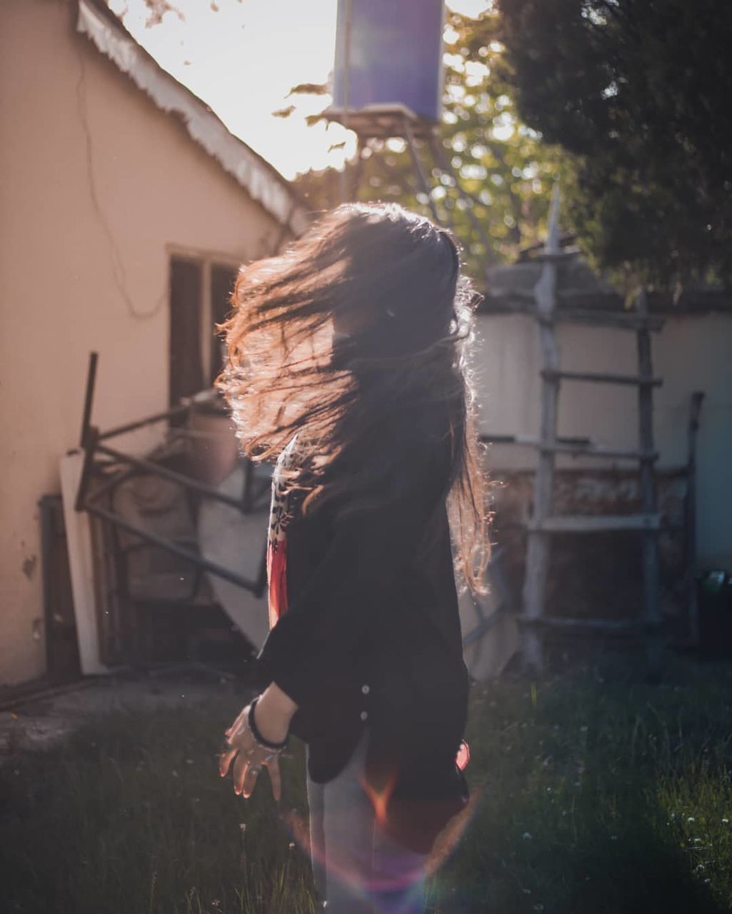 women, one person, real people, architecture, built structure, lifestyles, plant, building exterior, adult, hairstyle, rear view, hair, day, nature, long hair, leisure activity, front or back yard, grass, full length, outdoors, obscured face