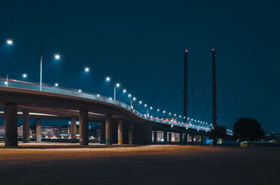 Low angle view of illuminated bridge against sky at night