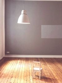 Illuminated lamp hanging on wall at home