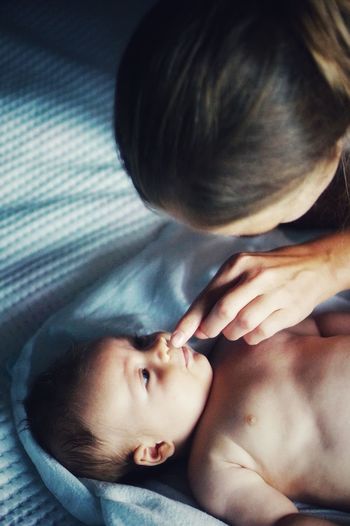 High angle view of mother and son on bed at home