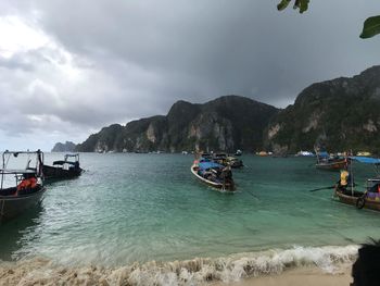 Boats moored on sea against sky