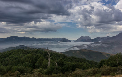 Scenic view of mountains against cloudy sky